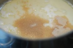 a pot filled with liquid and sugar on top of a stove burner next to a blue spatula