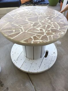 a table that has been made out of wood and is sitting on the concrete floor