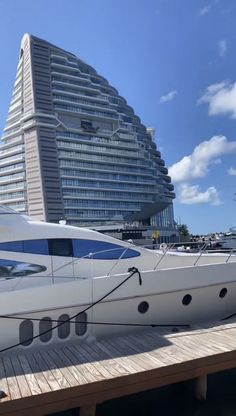 a large white boat sitting on top of a wooden dock next to a tall building