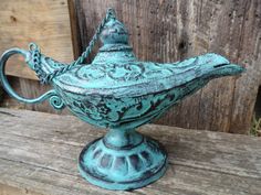 an old fashioned teapot sitting on top of a wooden table