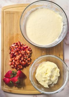 the ingredients to make strawberry shortcakes sit on a cutting board next to strawberries