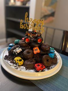 a birthday cake made to look like a truck and cars on top of donuts