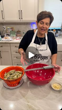 a woman in an apron preparing food on a kitchen counter with bowls and spoons