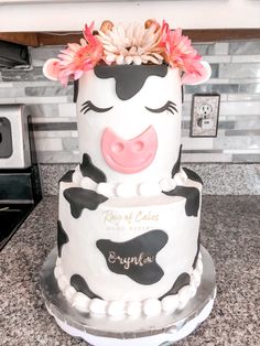 there is a cake decorated like a cow with flowers on top