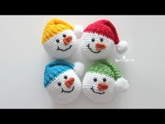 three crocheted snowmen with hats on them