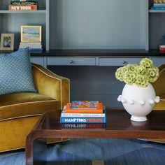 a living room with two chairs and a coffee table in front of a bookshelf