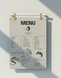 a menu hanging on a wall next to a table with food and utensils