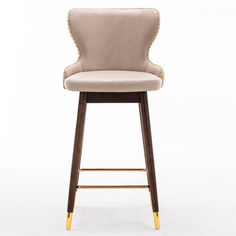 an upholstered bar stool with gold trimmings on the legs and back