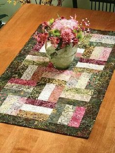 a wooden table topped with a vase filled with flowers