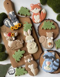 some decorated cookies are sitting on a cutting board