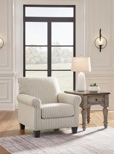 a living room with a chair, table and lamp next to a large open window