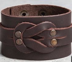 a brown leather bracelet with metal buttons