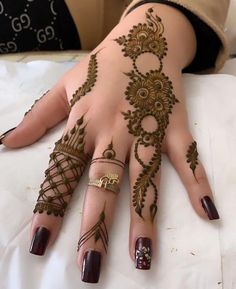 a woman's hand with henna tattoos on it