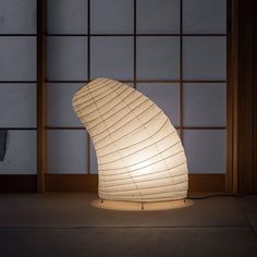 a white lamp sitting on top of a wooden floor