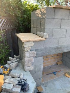 an outdoor fireplace is being built in the middle of some concrete blocks and surrounded by construction equipment