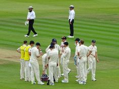 a group of men standing on top of a lush green field next to each other