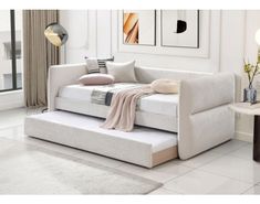 a white couch with pillows and blankets on it