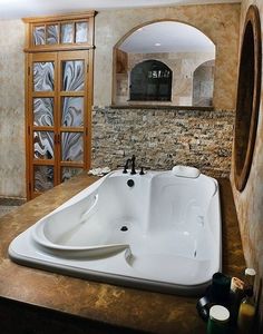 a large white bath tub sitting inside of a bathroom