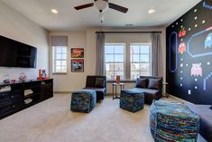 a living room filled with furniture and a flat screen tv mounted to the side of a wall