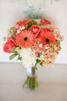 a bouquet of flowers sitting on top of a table next to a white and red wall