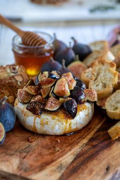 figs and bread on a cutting board with honey in the backgroung