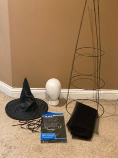 an assortment of items sitting on the floor next to a vase and hat rack in a corner