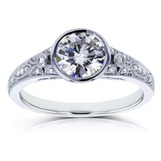 a white gold engagement ring with an old - fashioned setting and round brilliant cut diamonds