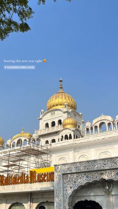 an ornate white building with gold domes under a blue sky