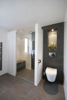 a bathroom with a toilet, sink and mirror in the wall next to each other