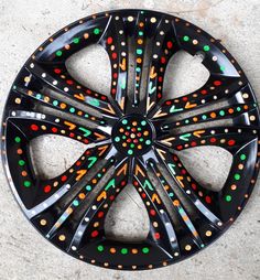 a black wheel with multicolored dots on it