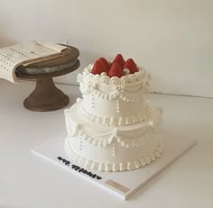 a three tiered cake with strawberries on top