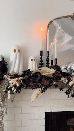 a mantel decorated with candles, skulls and other halloween decorations on top of it