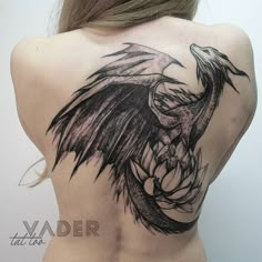 a woman's back with a tattoo design on it