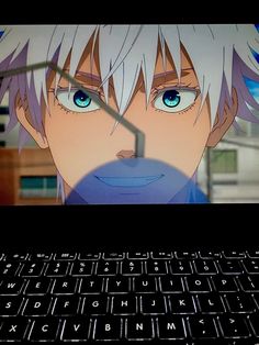 an anime character with blue eyes is looking at the screen on a laptop computer keyboard