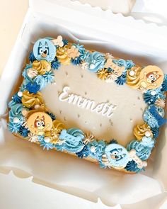 there is a cake in the box that says emmet on it and blue flowers