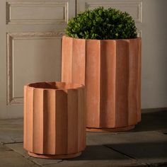 two planters sitting next to each other in front of a door