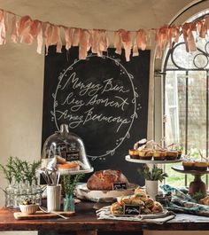 a table topped with lots of food next to a window