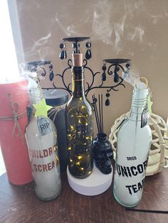 an assortment of liquor bottles sitting on top of a table next to candles and other items