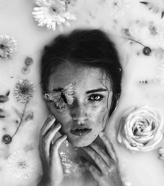 a woman with makeup and flowers around her face is shown in the middle of a photo