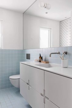 a bathroom with blue and white tiles on the walls, flooring and counter tops