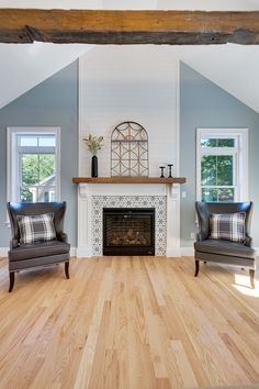 a living room with two chairs and a fireplace in the middle of it's walls