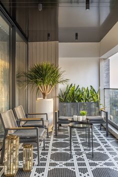 a balcony with chairs, tables and potted plants