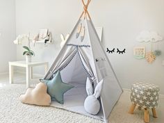 a child's teepee tent in the corner of a room with stuffed animals