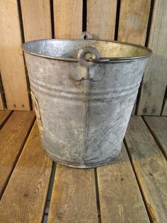 a metal bucket sitting on top of a wooden floor