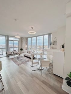 a living room filled with furniture and tall windows