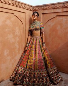 a woman in a colorful dress standing against a wall