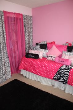 a pink and black bedroom with zebra print on the comforter, bedding and curtains