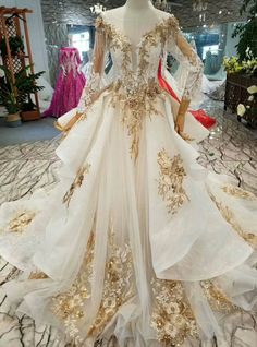 a white and gold wedding dress on display