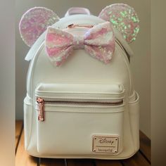 New Loungefly Backpack Product Id: 12603756 Loungefly Disney Minnie Mouse Iridescent Sequin Mini Backpack - Boxlunch Exclusive Minnie Mouse Leaves A Little Sparkle Everywhere She Goes. You Can Do The Same With This Faux Leather Mini Backpack By Loungefly! Minnie's Classic Ears And Bow Got An Iridescent Sequin Makeover, And We're In Love. Features A Brand Badge, Front Zip Pocket, Main Zip Compartment, Interior Zip Pocket, Rose Gold Tone Hardware, Adjustable Straps, Two Side Pockets, And Pink Interior Lining With An Allover Polka Dot Print. A Boxlunch Exclusive! Approx. 9" X 10 1/2" X 5" Polyurethane; Polyester Lining Disney Minnie Mouse White Bag, White Minnie Mouse School Bag, Loungefly Backpack, Iridescent Sequin, Loungefly Bag, Loungefly Disney, Pink Interior, Pink Sequin, Sequin Mini