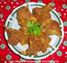 a white plate topped with meat covered in sauce and garnished with cilantro